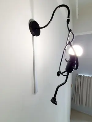 a black lamp hanging on a white wall at Explore The World at The CEO Studio Penang in Bayan Lepas