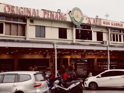 a building with cars and motorcycles parked in front of it at Explore The World at The CEO Studio Penang in Bayan Lepas