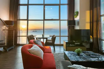a living room with a red couch and a large window at Maritime in George Town