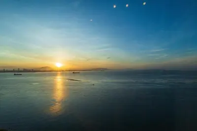 a sunset over a body of water with the sun setting at Maritime in George Town