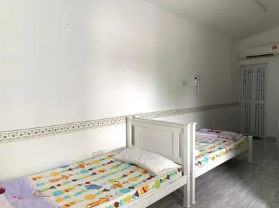 a white bed in a room with a white wall at 15 min to Qing Xin Ling Cultural Village Ipoh in Ipoh