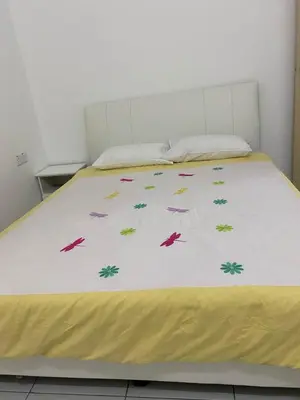 a bed with a yellow blanket on top of it at 15 min to Qing Xin Ling Cultural Village Ipoh in Ipoh