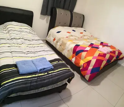 two beds sitting next to each other in a room at Mcz homestay ipoh town 2room 7pax free wifi in Ipoh