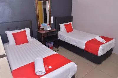 a hotel room with two beds with red and white pillows at NICE STAY HOTEL in Raub