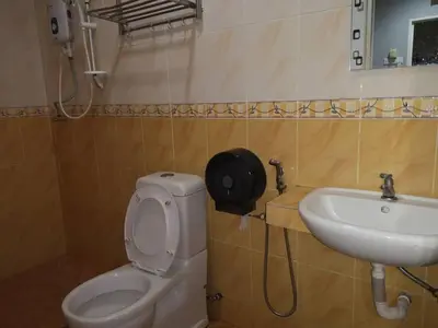 a bathroom with a toilet and a sink at NICE STAY HOTEL in Raub