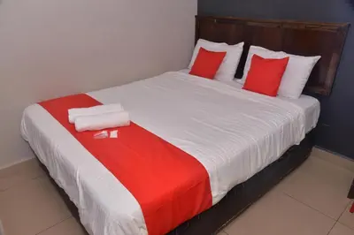 a large bed with red and white pillows on it at NICE STAY HOTEL in Raub