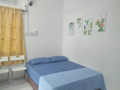 a bedroom with a blue bed and a window at FAFA ROOMSTAY TANJUNG MALIM in Tanjung Malim