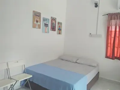 a bedroom with a blue bed in a white room at FAFA ROOMSTAY TANJUNG MALIM in Tanjung Malim
