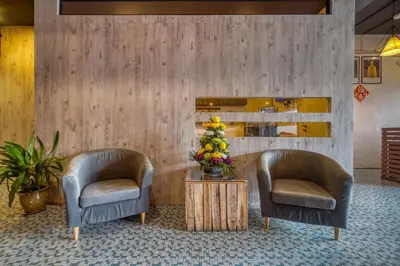 two chairs and a table with a vase of flowers at Parkland Express in Brinchang