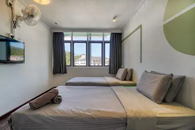 a bedroom with two beds and a large window at Parkland Express in Brinchang