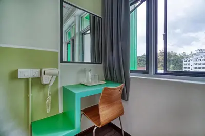 a room with a green desk and a window at Parkland Express in Brinchang