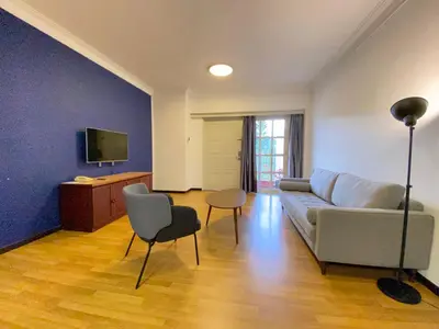a living room with a couch and a table and chairs at Parkland Suites in Brinchang