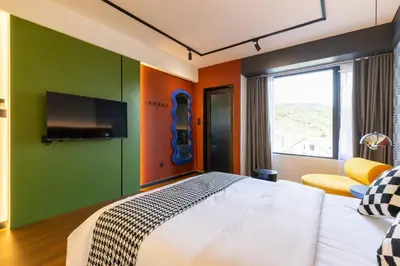 a bedroom with a bed and a flat screen tv at Parkland Suites in Brinchang