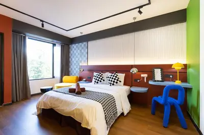 a bedroom with a large bed and a desk at Parkland Suites in Brinchang