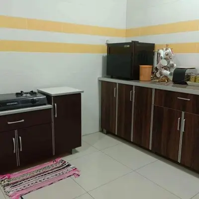 a kitchen with wooden cabinets and a counter top at TRIPLE A Homestay in Ipoh