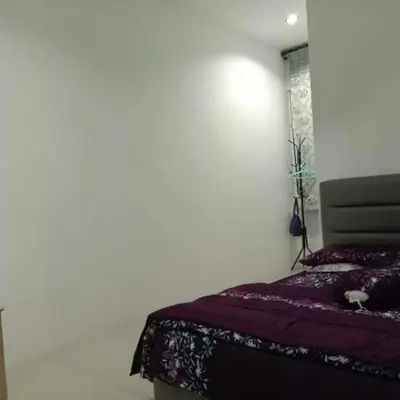 a bedroom with a bed in a white room at TRIPLE A Homestay in Ipoh
