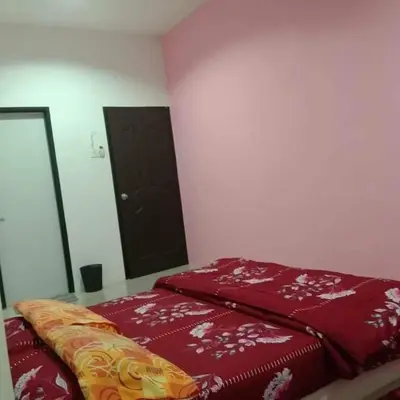a bedroom with a red bed and a black door at TRIPLE A Homestay in Ipoh