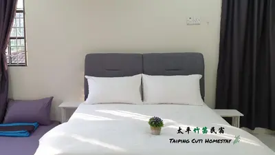 a bedroom with a white bed with a black headboard at Taiping Cuti Homstay \u592a\u5e73\u7af9\u7b1b\u6c11\u5bbf 5mins to Kuala Sepetang in Taiping
