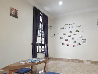 a room with a table and a clock on the wall at Taiping Cuti Homstay \u592a\u5e73\u7af9\u7b1b\u6c11\u5bbf 5mins to Kuala Sepetang in Taiping
