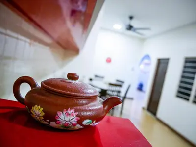 a brown tea pot sitting on a red table at Gather Here 62 5BR Town Center 5 Rooms in Taiping