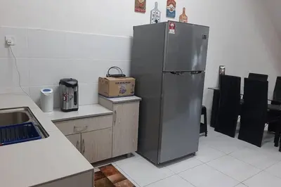 a kitchen with a stainless steel refrigerator and a box at HM Homestay Lahat, Station 18, Ipoh 'مسلم' in Lahat