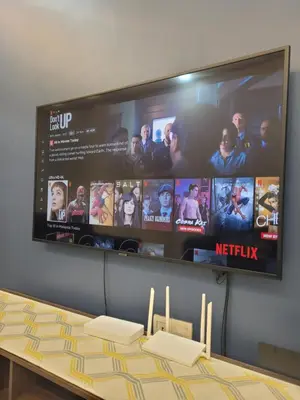 a flat screen tv hanging on a wall with a table at Ipoh Meru Modern Cozy Home NAZ IPOH HOMESTAY in Ipoh