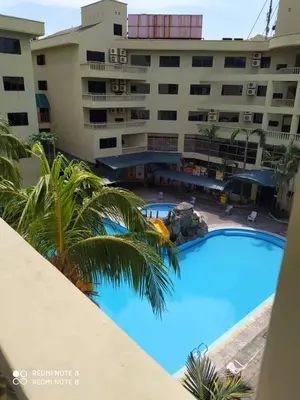 a large swimming pool in front of a large building at Pangkor fun fun fun apartment in Pangkor