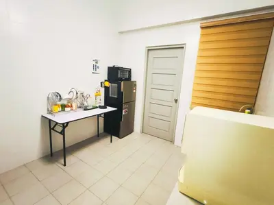 a kitchen with a table and a black refrigerator at The Venus Sitiawan Spacious High Floor Homestay 6 to 10 Pax in Kampong Lumut Kiri