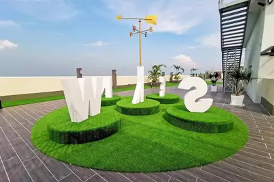 a grassy area with a sign on top of a building at The Venus Sitiawan Spacious High Floor Homestay 6 to 10 Pax in Kampong Lumut Kiri