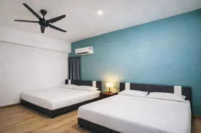 two beds in a hotel room with a ceiling fan at The Venus Sitiawan Spacious High Floor Homestay 6 to 10 Pax in Kampong Lumut Kiri