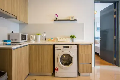 a kitchen with a washing machine under a counter at ❈ Tropicana 218 by ALV Suites ❈ in George Town