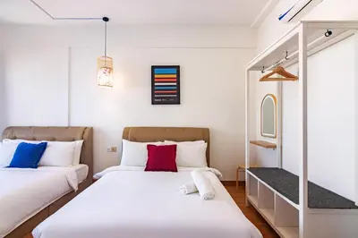 two beds in a room with white walls at ❈ Tropicana 218 by ALV Suites ❈ in George Town