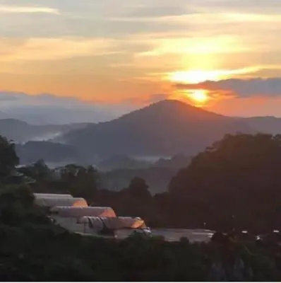a view of a mountain with the sun in the background at Kensington Sunrise at Sg Palas,PalasHorizon in Tanah Rata