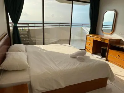 a bedroom with a bed and a dresser and a mirror at The View Ferringhi 3BR Apartment in Batu Ferringhi