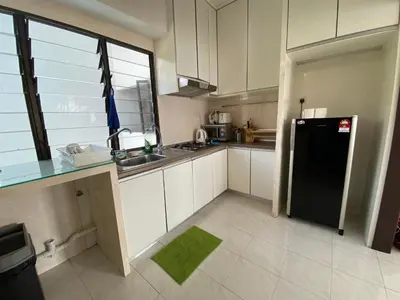 a kitchen with a black refrigerator and white cabinets at The View Ferringhi 3BR Apartment in Batu Ferringhi