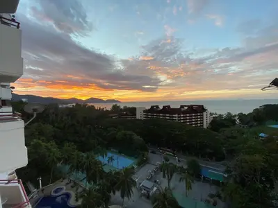 a sunset view of a city with a resort at The View Ferringhi 3BR Apartment in Batu Ferringhi