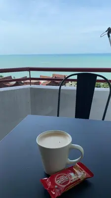 a cup of coffee sitting on top of a table at The View Ferringhi 3BR Apartment in Batu Ferringhi