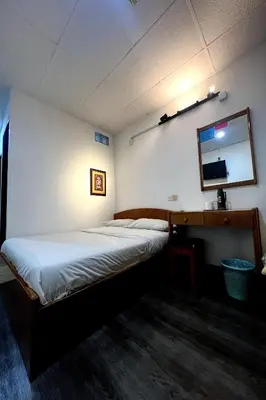 a bedroom with a bed and a mirror on the wall at Madani Muslim Hotel Cameron Highland in Cameron Highlands