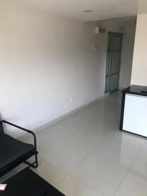 a room with a white wall and a tv on the floor at The Ceo Suites in Bayan Lepas