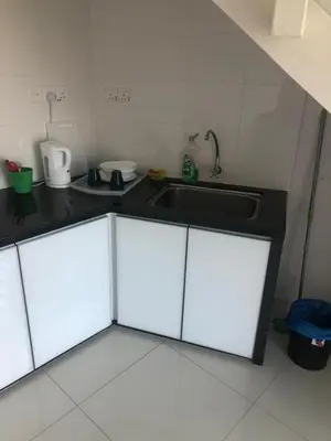 a kitchen with white cabinets and a sink at The Ceo Suites in Bayan Lepas