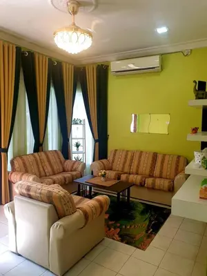 a living room with two couches and a table at CEMPAKA IRIS HOMESTAY in Kampung Bota Kiri