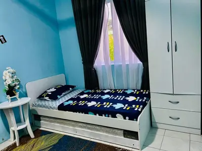 a bedroom with a bed with blue walls and a window at CEMPAKA IRIS HOMESTAY in Kampung Bota Kiri