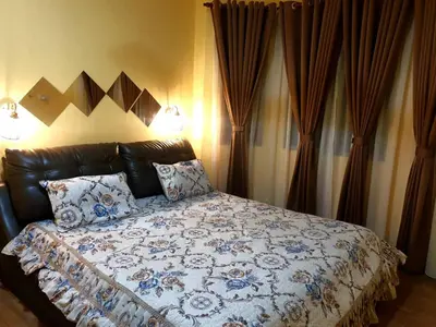 a bedroom with a bed with a blue and white comforter at CEMPAKA IRIS HOMESTAY in Kampung Bota Kiri