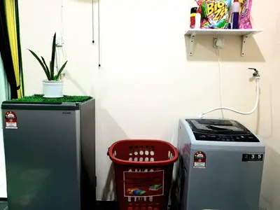 a refrigerator and a trash can in a room at CEMPAKA IRIS HOMESTAY in Kampung Bota Kiri