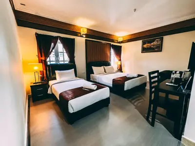 a hotel room with two beds and a desk at Seriental Hotel I check in 3pm-11pm only in Tanjong Tokong