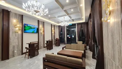 a lobby with a couch and tables and a chandelier at VISTA HOTEL in Kampar