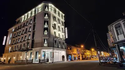 a tall building on a city street at night at VISTA HOTEL in Kampar