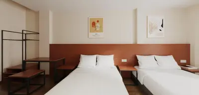 a hotel room with two beds and a desk at VISTA HOTEL in Kampar