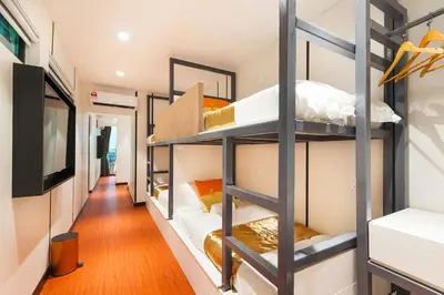 a room with four bunk beds with a television at Villa Chee in Sekincan