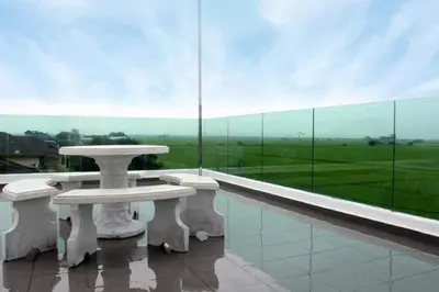 a balcony with two tables and a large glass window at Villa Chee in Sekincan